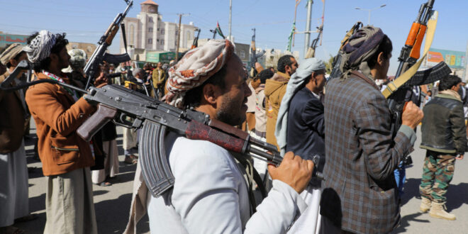 Newly recruited Houthi fighters hold up firearms during a ceremony at the end of their training in Sanaa