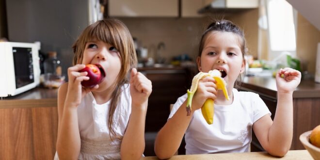 baby sisters having healthy snack 23 2148281920