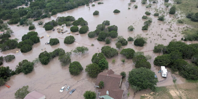 Houses and cars are partially submerged in flood waters in an aerial view near Kerrville