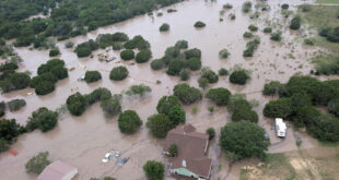 Houses and cars are partially submerged in flood waters in an aerial view near Kerrville